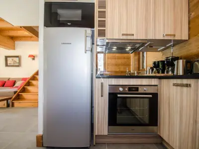 a white refrigerator in a kitchen with a couch at Chalet mitoyen aux pieds des pistes pour 6 pers., animaux admis, à Chamonix - FR-1-343-225 in Chamonix-Mont-Blanc