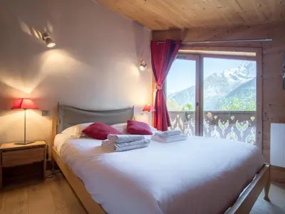 a bedroom with a large bed with a large window at Chalet mitoyen aux pieds des pistes pour 6 pers., animaux admis, à Chamonix - FR-1-343-225 in Chamonix-Mont-Blanc