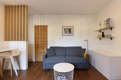 a living room with a blue couch and a table at Vallot - Chamonix Centre in Chamonix-Mont-Blanc