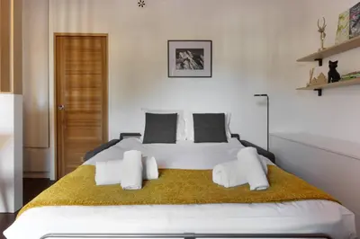a bedroom with a large white bed with towels on it at Vallot - Chamonix Centre in Chamonix-Mont-Blanc
