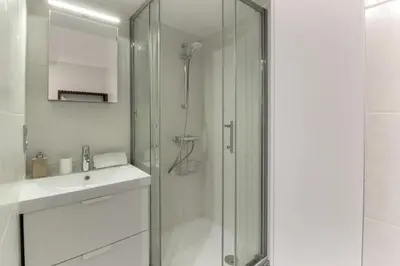 a white bathroom with a shower and a sink at Vallot - Chamonix Centre in Chamonix-Mont-Blanc