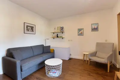 a living room with a blue couch and a chair at Vallot - Chamonix Centre in Chamonix-Mont-Blanc