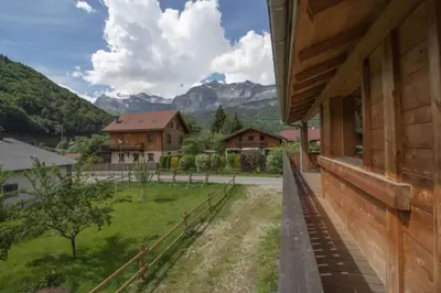 a house with a view of a field and mountains at Le Lac - Servoz - Appartement paisible de 70m² in Les Houches