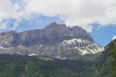 a rocky mountain with trees in front of it at Le Lac - Servoz - Appartement paisible de 70m² in Les Houches