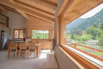 a kitchen with a table and chairs and a large window at Le Lac - Servoz - Appartement paisible de 70m² in Les Houches