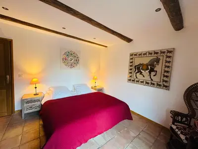 a bedroom with a red bed and a picture of a horse on the wall at Le Chalet de Bémont in Samoëns