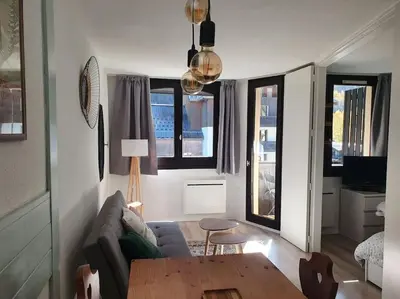 a living room with a couch and a table at Superbe 2 pièces, centre vue Mont-Blanc avec balcon et parking gratuit in Chamonix-Mont-Blanc