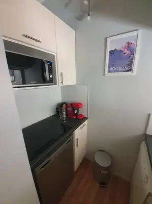 a small kitchen with a microwave and a counter at Superbe 2 pièces, centre vue Mont-Blanc avec balcon et parking gratuit in Chamonix-Mont-Blanc