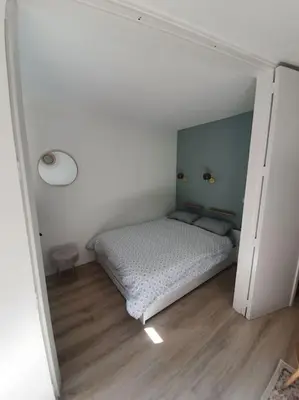a small bedroom with a bed in a white room at Superbe 2 pièces, centre vue Mont-Blanc avec balcon et parking gratuit in Chamonix-Mont-Blanc