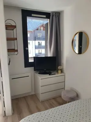 a bedroom with a television on a dresser with a window at Superbe 2 pièces, centre vue Mont-Blanc avec balcon et parking gratuit in Chamonix-Mont-Blanc