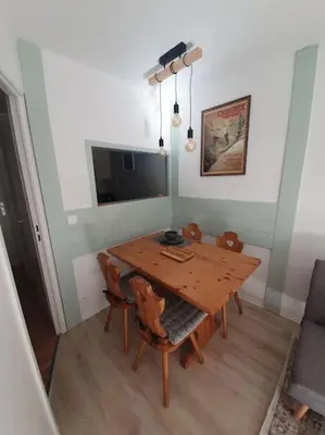 a dining room with a wooden table and chairs at Superbe 2 pièces, centre vue Mont-Blanc avec balcon et parking gratuit in Chamonix-Mont-Blanc