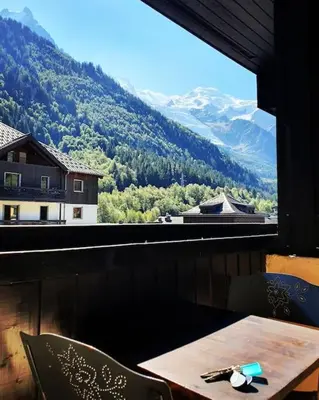 a table and chairs with a view of a mountain at Superbe 2 pièces, centre vue Mont-Blanc avec balcon et parking gratuit in Chamonix-Mont-Blanc