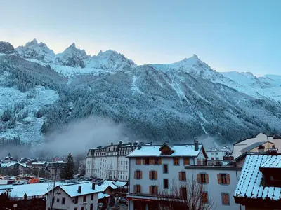 a city with snow covered mountains in the background at Chamonix Bellevue in Chamonix-Mont-Blanc
