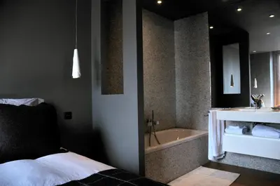 a bedroom with a bed and a tub and a sink at Chamonix Bellevue in Chamonix-Mont-Blanc