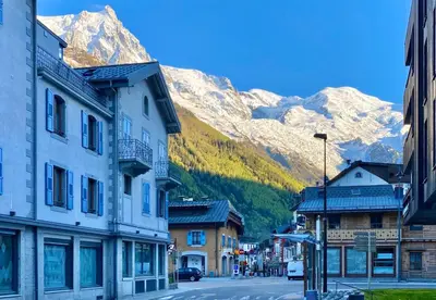 a street in a town with mountains in the background at Chamonix Bellevue in Chamonix-Mont-Blanc