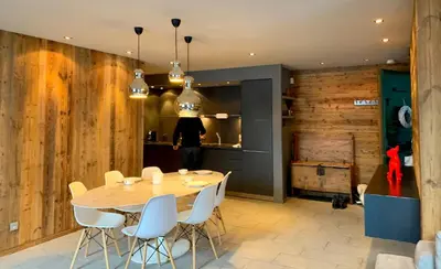a dining room with a table and white chairs at Chamonix Bellevue in Chamonix-Mont-Blanc