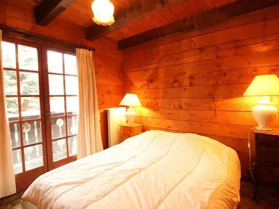 a bedroom with a bed in a log cabin at Chalet 4 chambres sur pistes débutants avec balcon et parking, à 350m des commerces - FR-1-572-196 in Arâches-la-Frasse