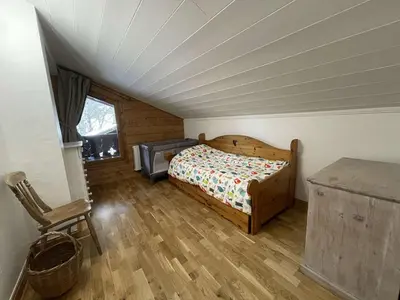 a bedroom with a bed and a desk in a attic at 4 pièces 6 pers : proche spa, ski bus, parking, WIFI - FR-1-572-119 in Arâches-la-Frasse