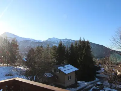 a house with snow on the roof with mountains in the background at Appartement Rénové 6/8 Pers, Pied des Pistes, Balcon, Garage, WiFi - Arâches-la-Frasse - FR-1-572-139 in Arâches-la-Frasse