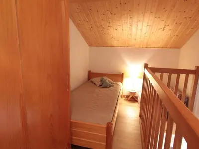a small bedroom with a bed and a staircase at Appartement Rénové 6/8 Pers, Pied des Pistes, Balcon, Garage, WiFi - Arâches-la-Frasse - FR-1-572-139 in Arâches-la-Frasse