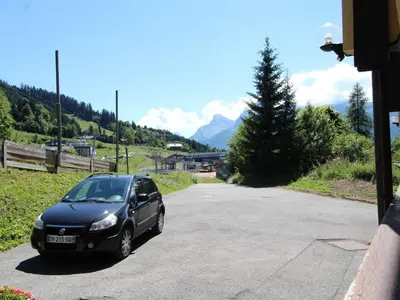 a black car parked on the side of a road at Ski aux pieds, 2 pièces rénové, 5 couchages, terrasse, parking, proche commerces et services - FR-1-572-145 in Arâches-la-Frasse