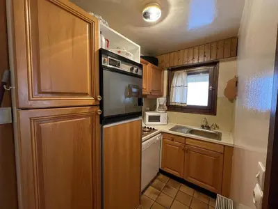 a small kitchen with a refrigerator and a sink at Ski aux pieds, 2 pièces rénové, 5 couchages, terrasse, parking, proche commerces et services - FR-1-572-145 in Arâches-la-Frasse
