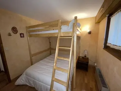 a bunk bed with a ladder in a room at Ski aux pieds, 2 pièces rénové, 5 couchages, terrasse, parking, proche commerces et services - FR-1-572-145 in Arâches-la-Frasse
