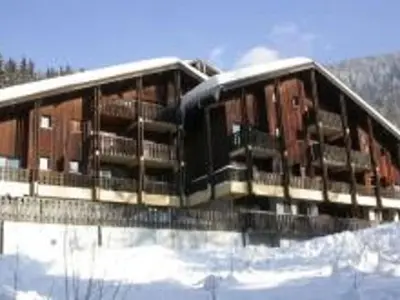 a building in the snow with snow on it at Ski aux pieds, 2 pièces rénové, 5 couchages, terrasse, parking, proche commerces et services - FR-1-572-145 in Arâches-la-Frasse