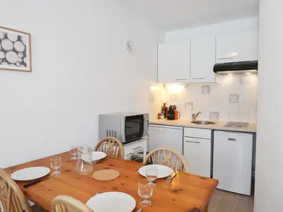 a kitchen with a wooden table and chairs in a kitchen at Appartement lumineux avec piscine et parking près du centre - FR-1-624-125 in Samoëns