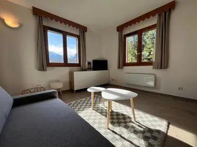 a living room with a couch and a table and two windows at Appartement lumineux avec piscine et parking près du centre - FR-1-624-125 in Samoëns