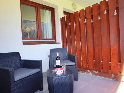 a room with two chairs and a bottle of wine at Appartement lumineux avec piscine et parking près du centre - FR-1-624-125 in Samoëns