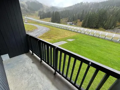 a balcony with a view of a field and a road at Studio idéal pour l'hiver au pied des pistes - FR-1-687-112 in Arâches-la-Frasse