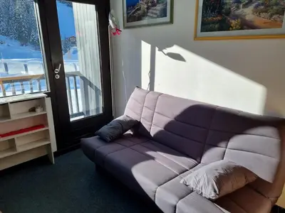 a purple couch in a living room with a window at Studio idéal pour l'hiver au pied des pistes - FR-1-687-112 in Arâches-la-Frasse