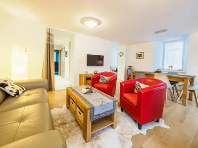 a living room with two red chairs and a table at DIFY Clos des Roches - Chamonix in Chamonix-Mont-Blanc