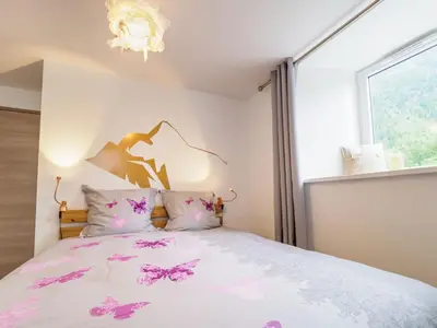 a bedroom with a bed with pink flowers on it at DIFY Clos des Roches - Chamonix in Chamonix-Mont-Blanc