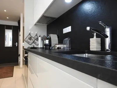 a kitchen with a sink and a black wall at DIFY Clos des Roches - Chamonix in Chamonix-Mont-Blanc