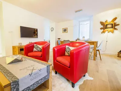 a living room with two red chairs and a table at DIFY Clos des Roches - Chamonix in Chamonix-Mont-Blanc