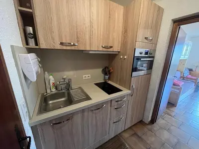 a kitchen with wooden cabinets and a sink at Studio 4 pers avec lave-linge, pied des pistes et parking couvert à Arâches-la-Frasse - FR-1-572-266 in Arâches-la-Frasse