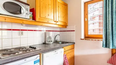 a kitchen with a stove and a microwave at Les Sitelles - 11 - Piscine Appart 6 pers in Morillon