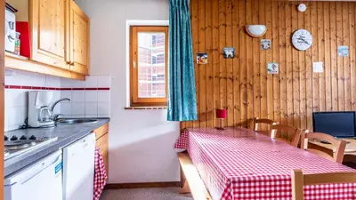 a kitchen with a table with a red and white checkered table cloth at Les Sitelles - 11 - Piscine Appart 6 pers in Morillon