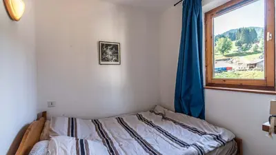 a bedroom with a bed and a window at Les Sitelles - 18 - Belle vue Appart 6 pers in Morillon