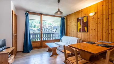 a living room with a table and a chair at Les Sitelles - 18 - Belle vue Appart 6 pers in Morillon