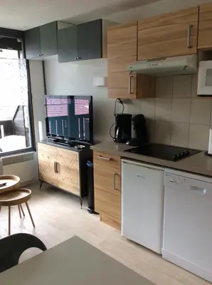 a kitchen with wooden cabinets and a counter top at Grand Morillon - 104 - Montagne Belle Vue Studio 4 in Morillon