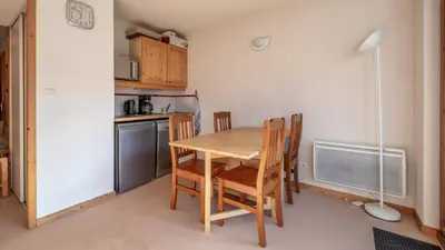a small kitchen with a wooden table and chairs at Les Eterlous - 39- Appart pied des pistes 6 pers in Morillon