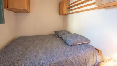 a small bedroom with a bed with a pillow at Les Eterlous - 39- Appart pied des pistes 6 pers in Morillon