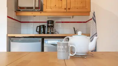 a kitchen with a table with a tea pot on the counter at Les Eterlous - 39- Appart pied des pistes 6 pers in Morillon