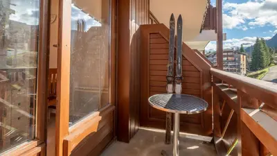 a chair on a balcony with a window at Les Eterlous - 39- Appart pied des pistes 6 pers in Morillon