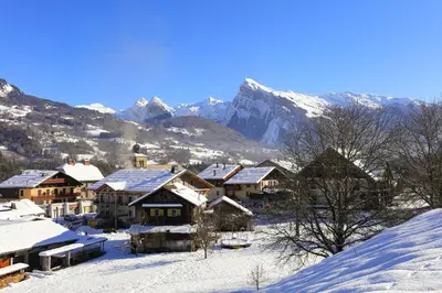 a snow covered village with mountains in the background at Le Grand Neige - 36 - Appart Montagne 6 pers in Morillon
