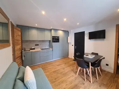 a living room with a couch and a table and a kitchen at Spacieux 2 pièces + cabine, idéal famille, 5 pers, centre village, proche commerces et pistes - FR-1-572-156 in Arâches-la-Frasse