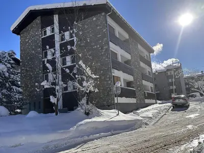 a building in the snow with a tree in front of it at Spacieux 2 pièces + cabine, idéal famille, 5 pers, centre village, proche commerces et pistes - FR-1-572-156 in Arâches-la-Frasse